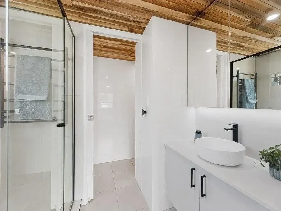 Custom white bathroom vanity with vessel sink, black fixtures and timber ceiling, Kings Beach