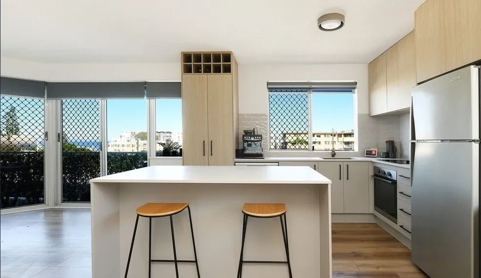 White laundry cabinetry with overhead storage and stone benchtop, Maroochydore